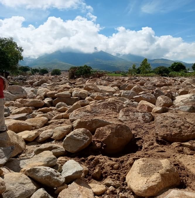 Boulders and debris carried down from the mountains onto farmland after the cyclone